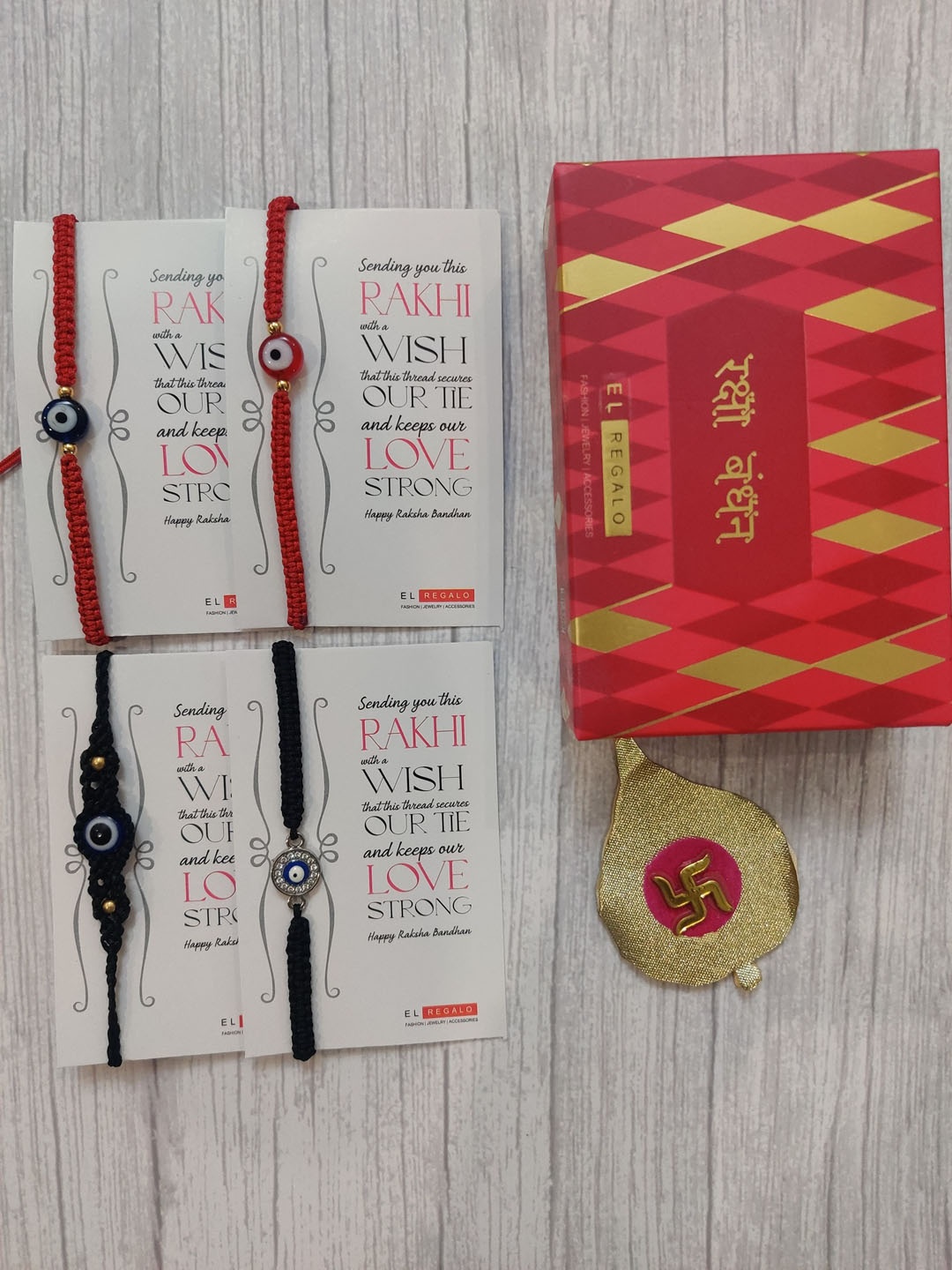 

EL REGALO Adults Set of 4 Red & Black Evil Eye Wrap Around Rakhi With Roli Chawal & Card