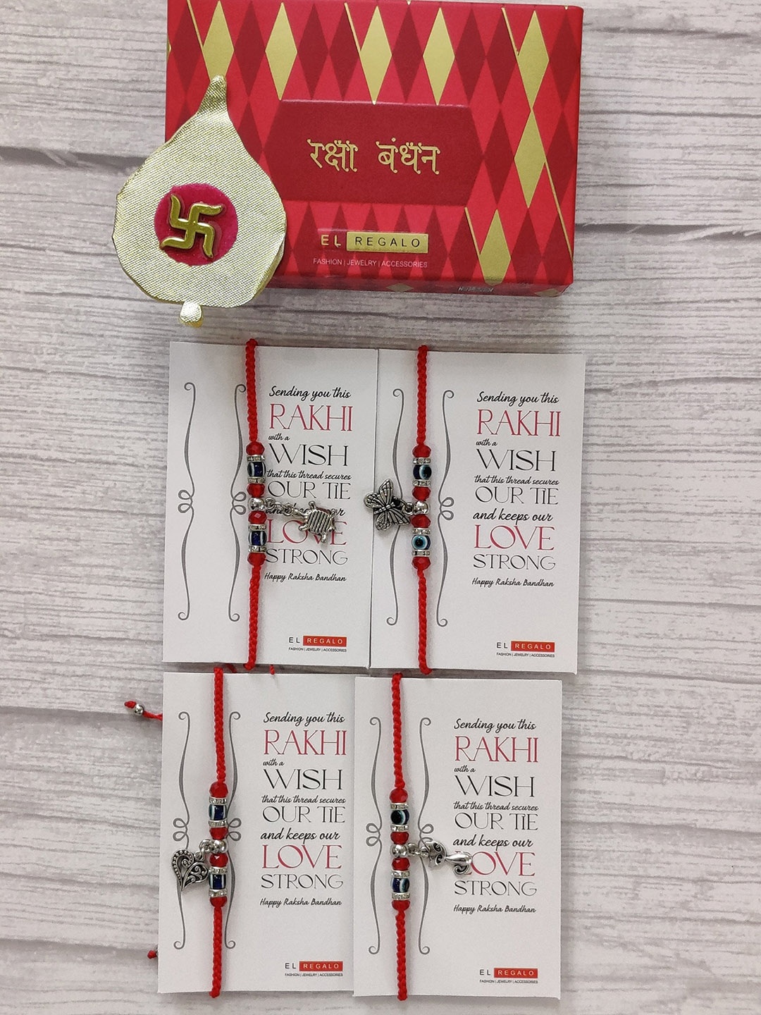 

EL REGALO Set Of 4 Red & Silver Coloured Evil Eye Wrap Around Rakhi With Roli Chawal & Raksha Bandhan Greeting Card