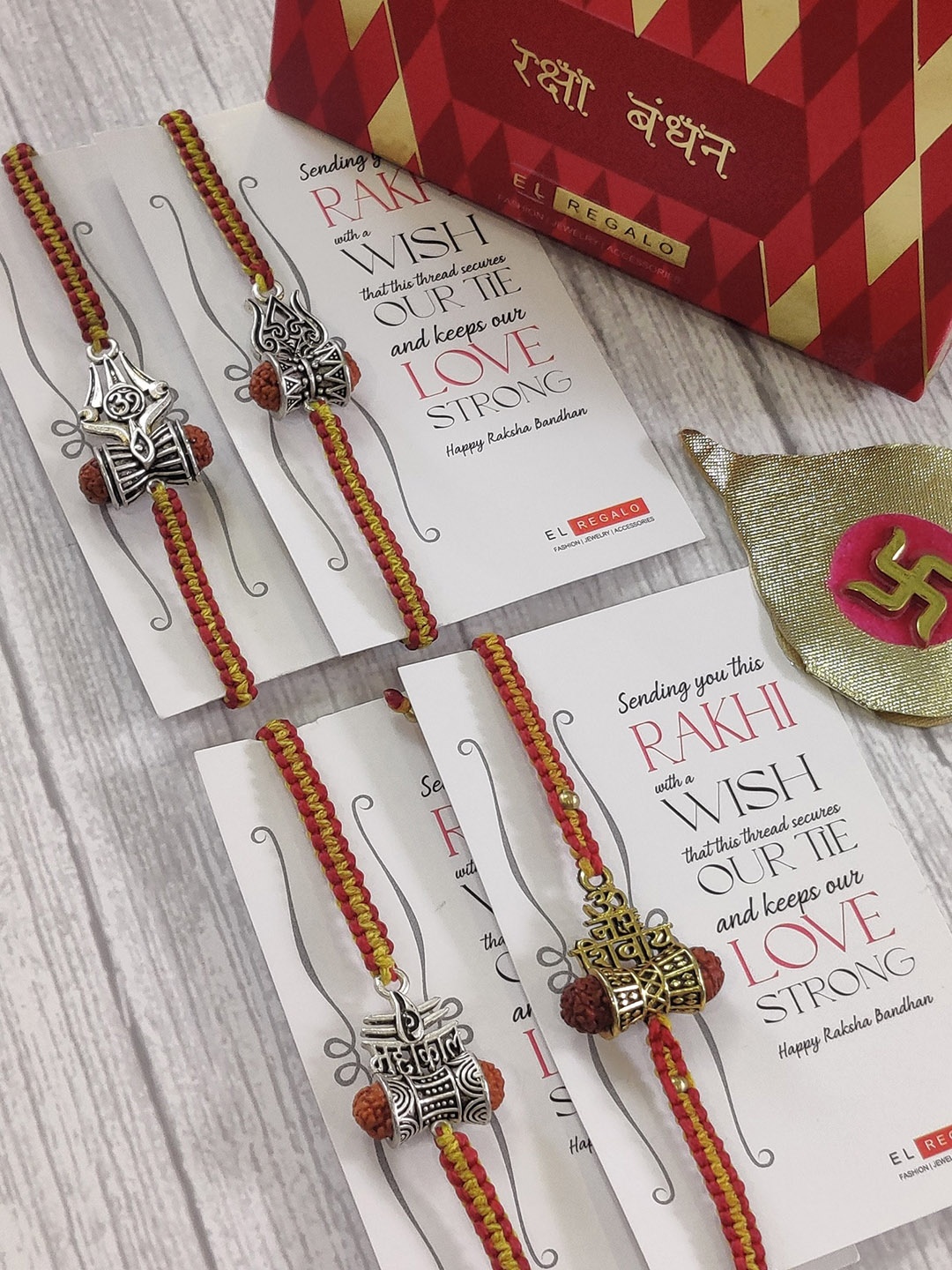 

EL REGALO Set Of 4 Red & Silver Coloured Rudrakh Wrap Around Rakhi With Roli Chawal & Raksha Bandhan Greeting Card