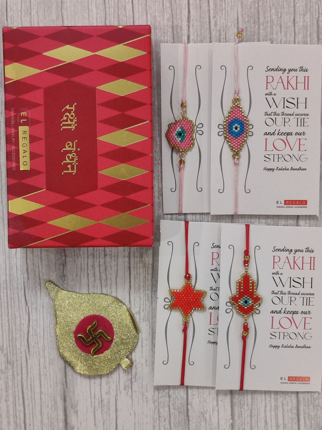 

EL REGALO Set Of 4 Red & Pink Evil Eye Beaded Wrap Around Rakhi With Roli Chawal & Raksha Bandhan Greeting Card