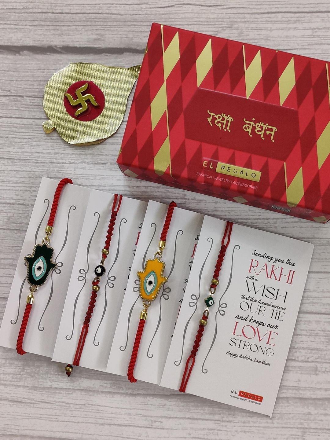 

EL REGALO Set Of 4 Red & Yellow Evil Eye Wrap Around Rakhi With Roli Chawal & Raksha Bandhan Greeting Card