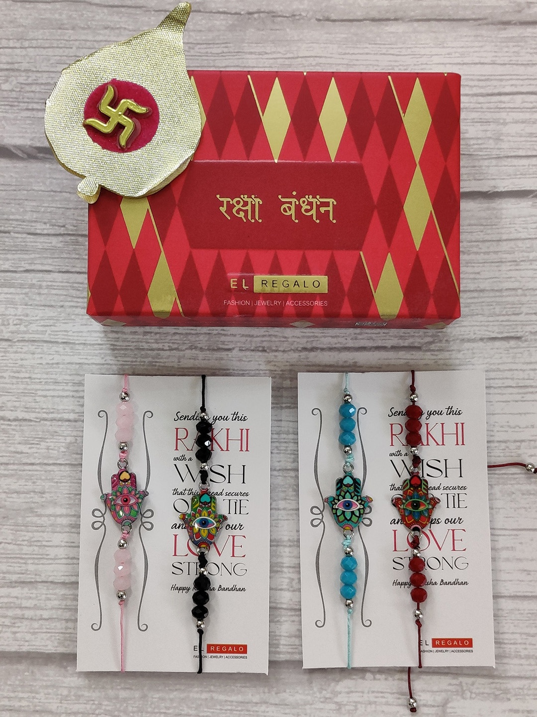 

EL REGALO Set Of 4 Red & Gold Evil Eye Beaded Rakhi With Roli Chawal & Greeting Card