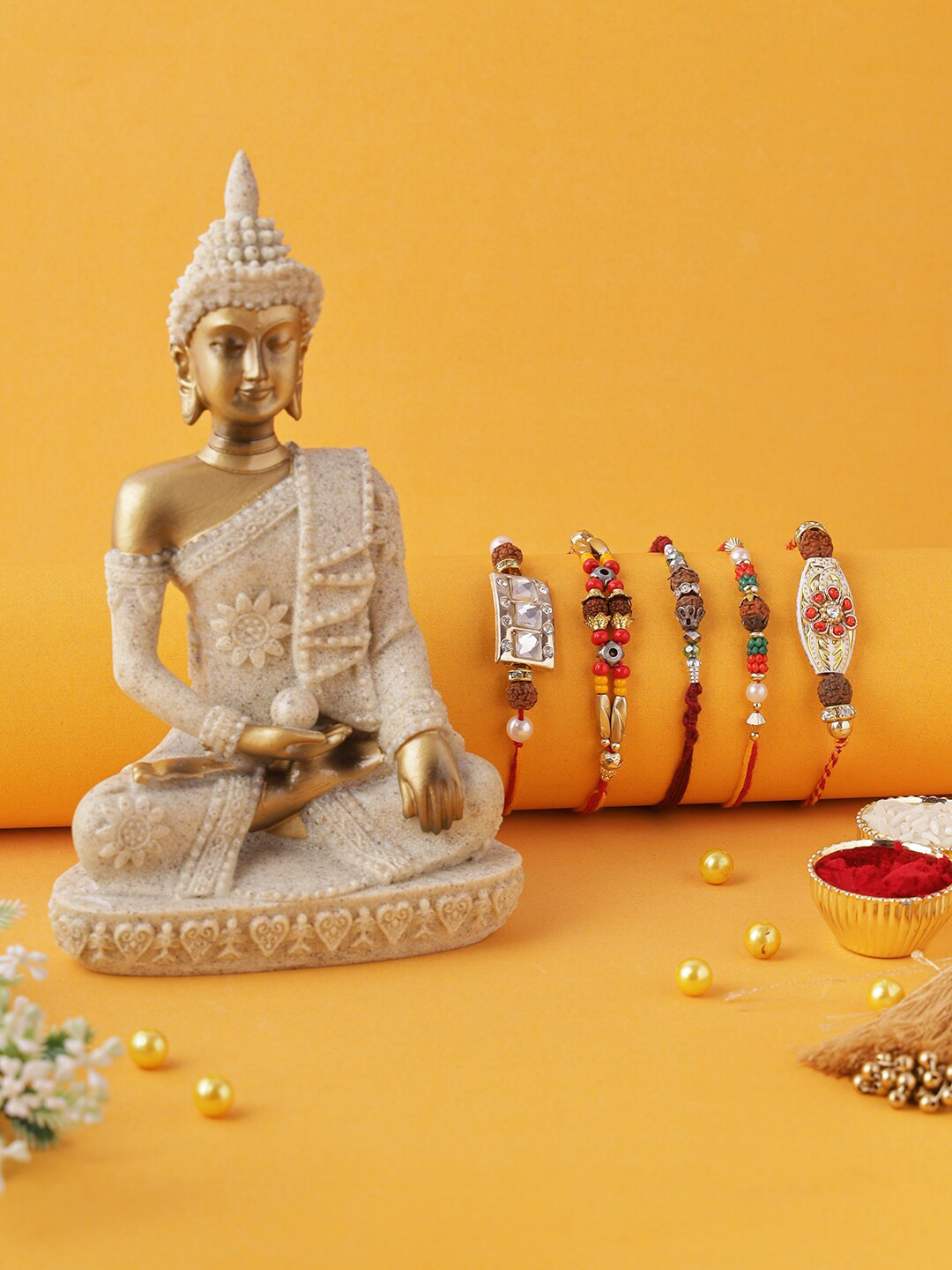 

Aapno Rajasthan Set of 5 Gold Coloured & Red Thread Rakhi With Buddha Statue, Roli Chawal & Raksha Bandhan Greeting Card