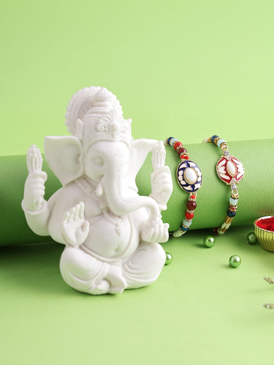 

Aapno Rajasthan Polyresin Ganesha Idol with Set of 2 Meena Work Rakhi, Red