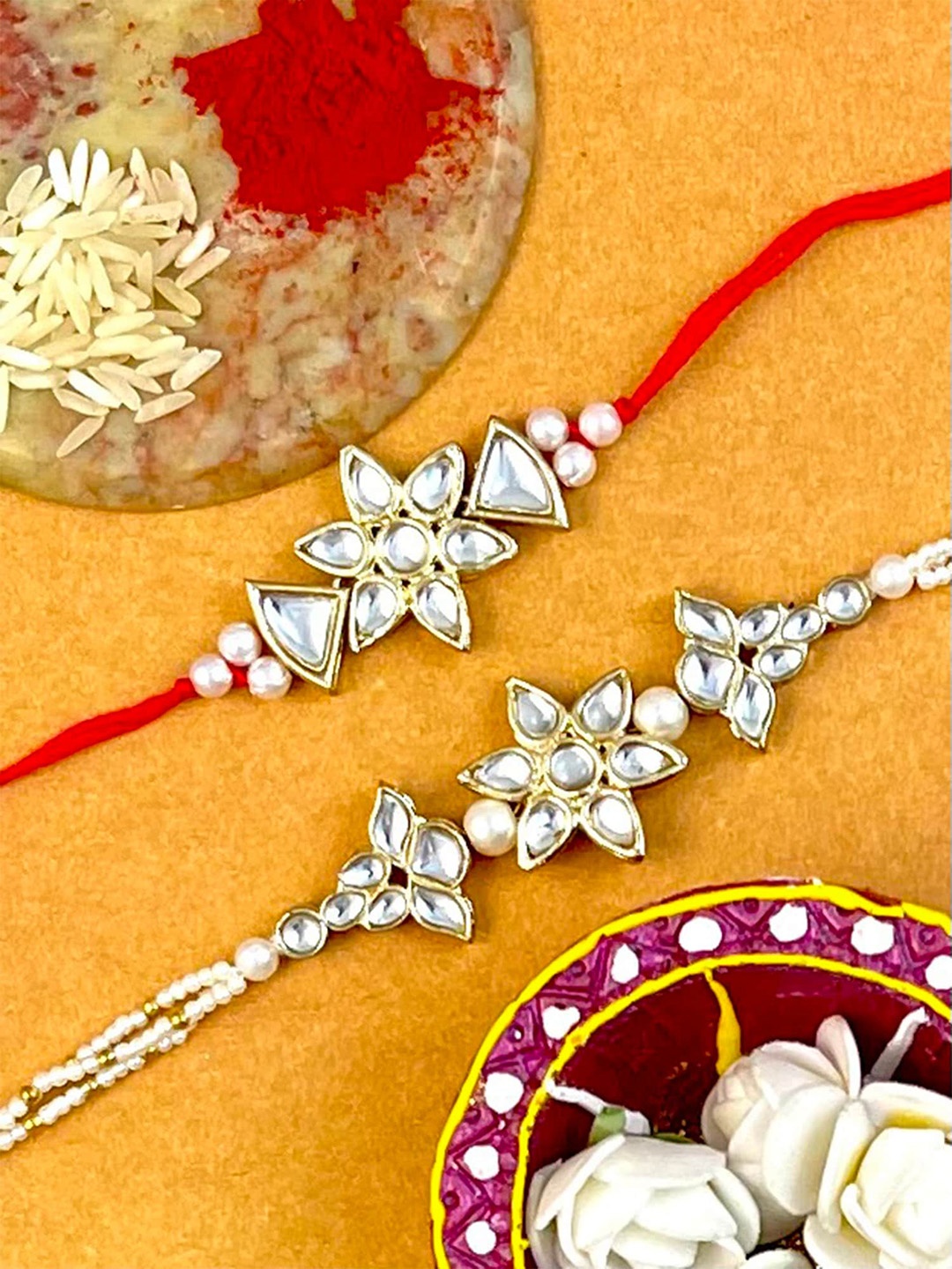 

KARATCART Set Of 2 Gold-Toned & White Stone-Studded & Beaded Rakhi With Roli & Chawal