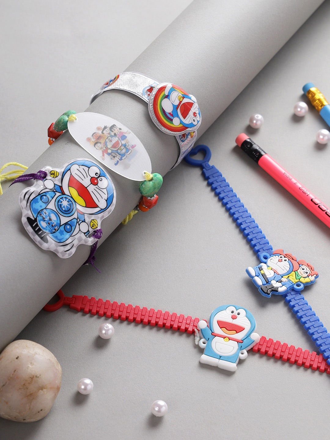 

Aapno Rajasthan Set Of 5 Blue & White Doremon-Charm Rakhi With Roli Rice & Rakhi Card