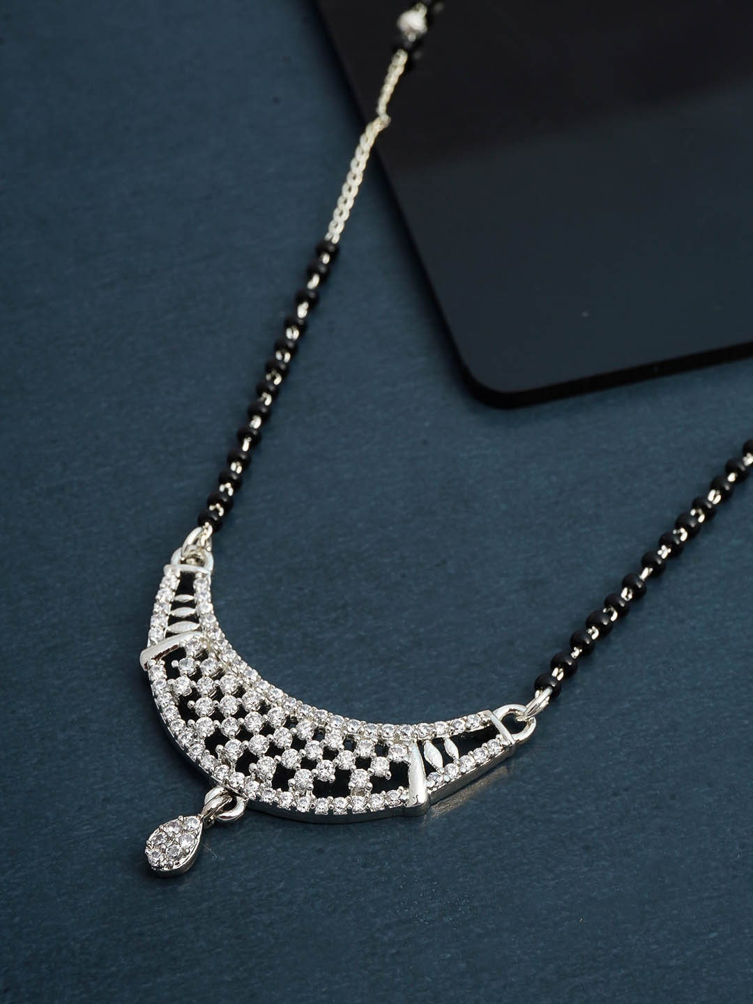 

Urmika Silver-Coloured Black Beaded White AD Stone Studded Mangalsutra
