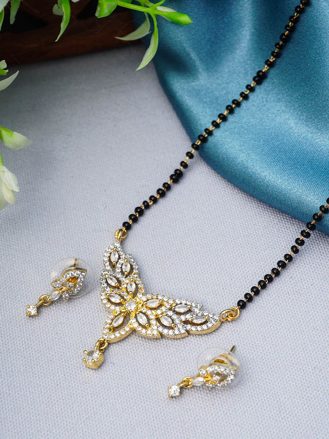 

Urmika Gold-Plated Black Beaded White AD-Studded Mangalsutra With Earring