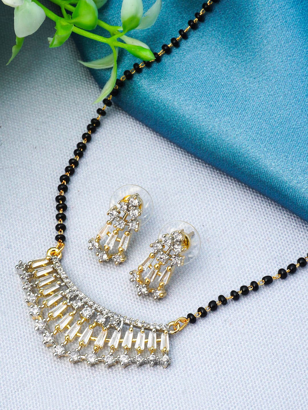 

Urmika Gold Plated Black Beaded White AD Studded Mangalsutra With Earring