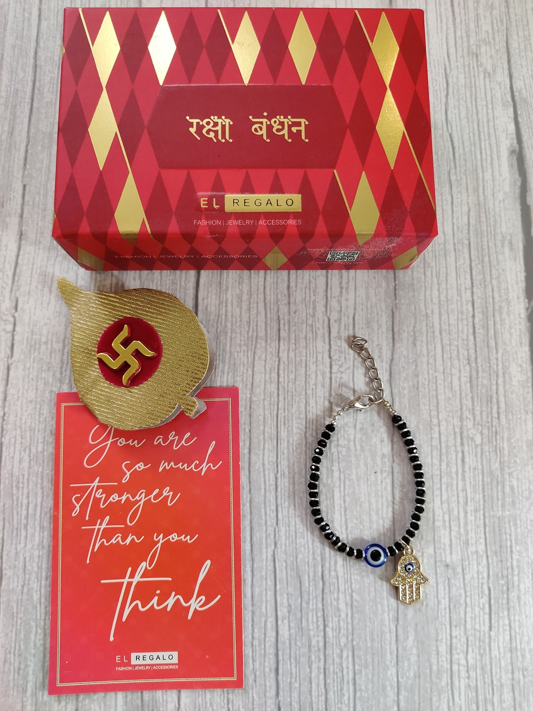 

EL REGALO Gold Coloured Black Evil Eye Baby Rakhi With Roli Chawal Raksha Bandhan Card