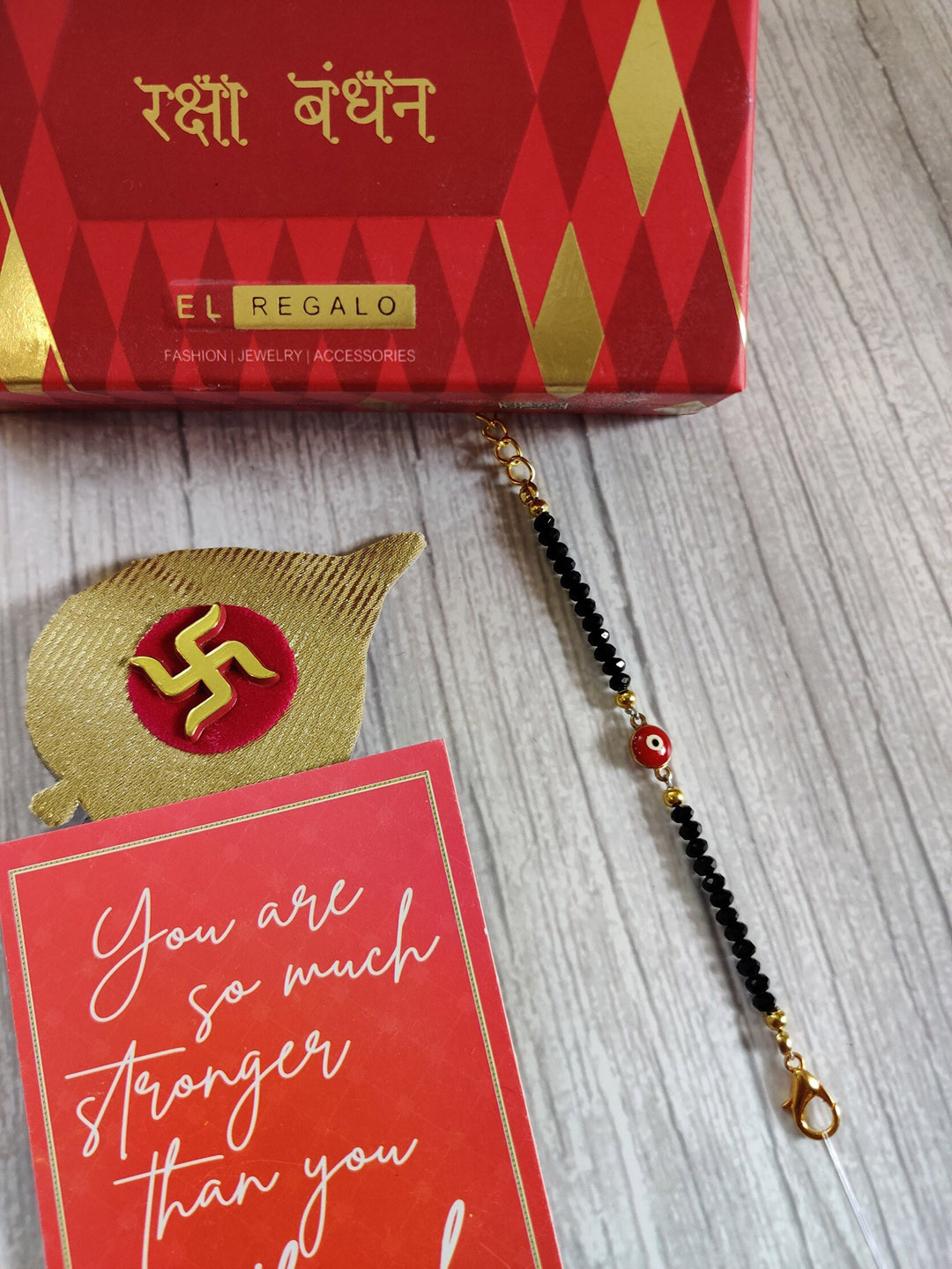 

EL REGALO Baby Gold-Coloured Red Evil Eye Rakhi With Roli Chawal & Raksha Bandhan Card
