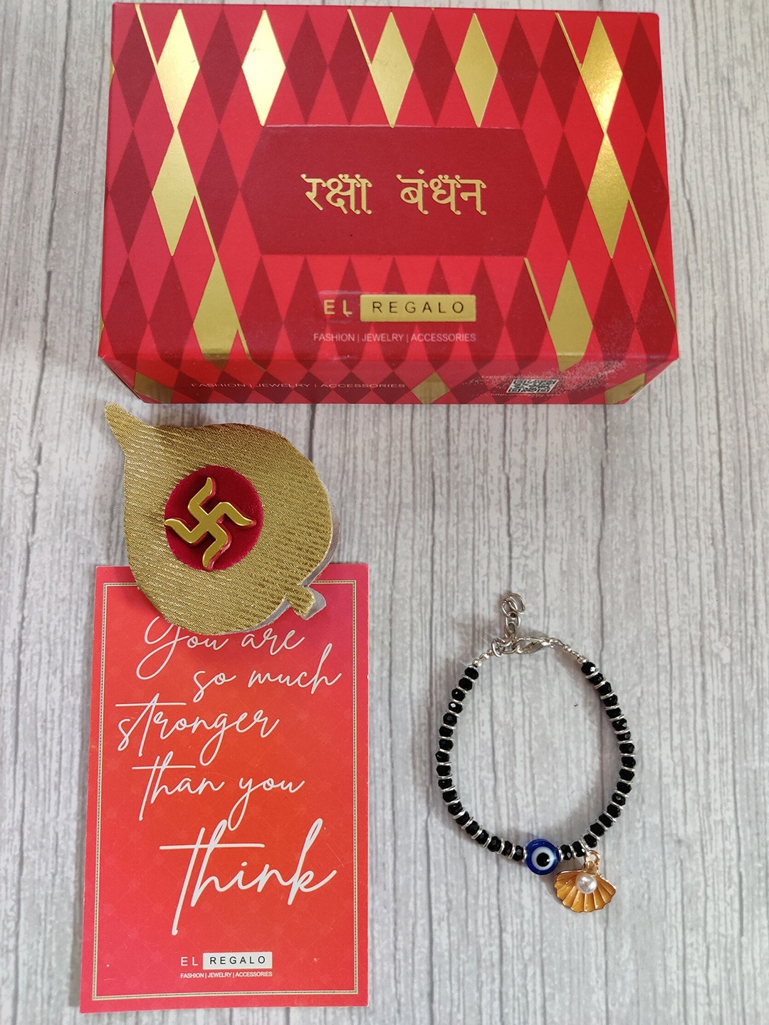 

EL REGALO Baby Silver Coloured Blue Evil Eye Rakhi With Roli Chawal & Rakhi Card