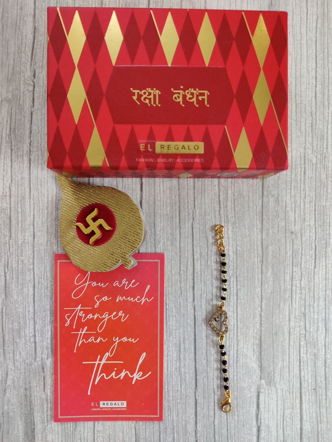 EL REGALO Baby Gold Coloured Black Evil Eye Rakhi With Roli Chawal & Rakhi Card