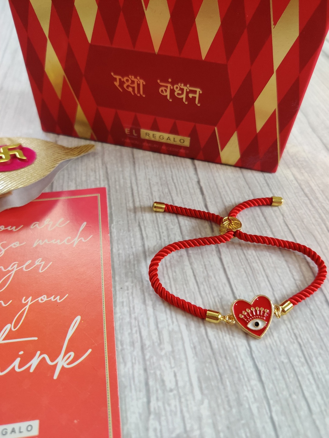 

EL REGALO Red & Gold Coloured Evil Eye Wrap Around Rakhi With Roli Chawal & Raksha Bandhan Greeting Card