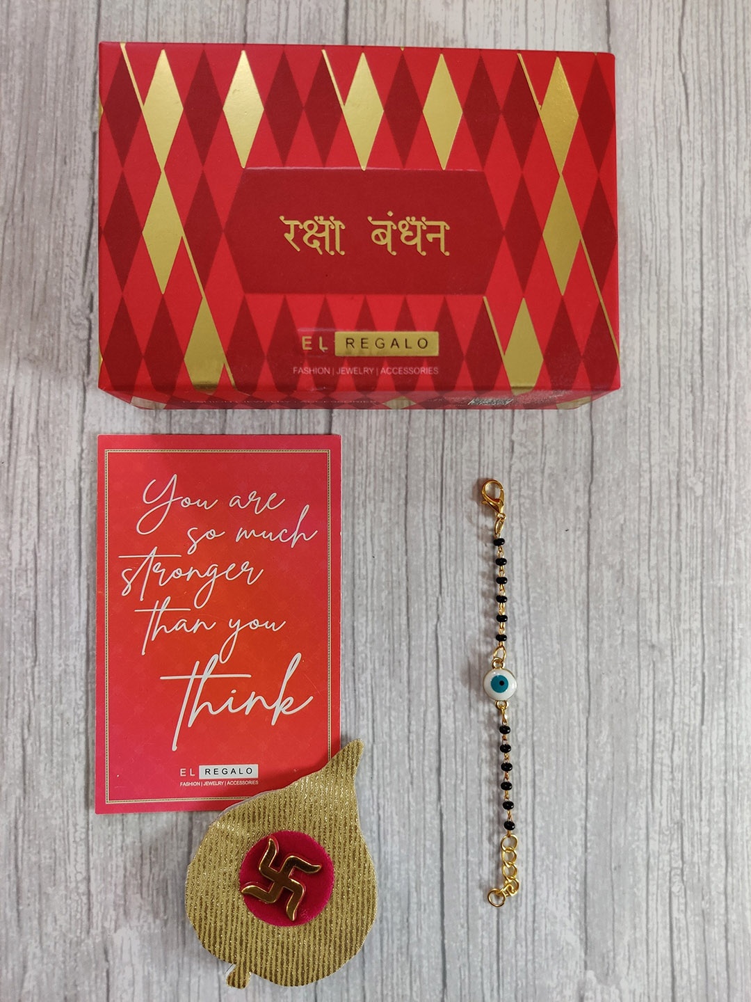 

EL REGALO Gold Coloured White Evil Eye Rakhi for baby with Greeting Card Set