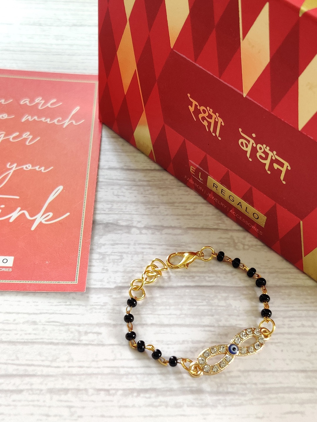 

EL REGALO Baby Gold-Plated Nazaria Evil Eye Rakhi With Greeting Card Roli Chawal, Black