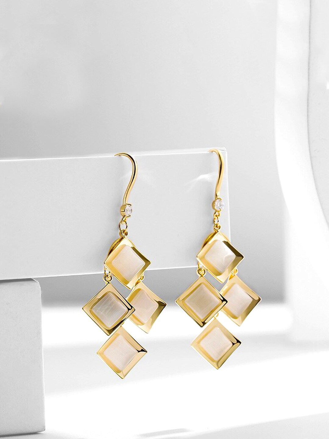 

Yellow Chimes Gold Plated White Color Crystal Studded Geometrical Designed Drop Earrings