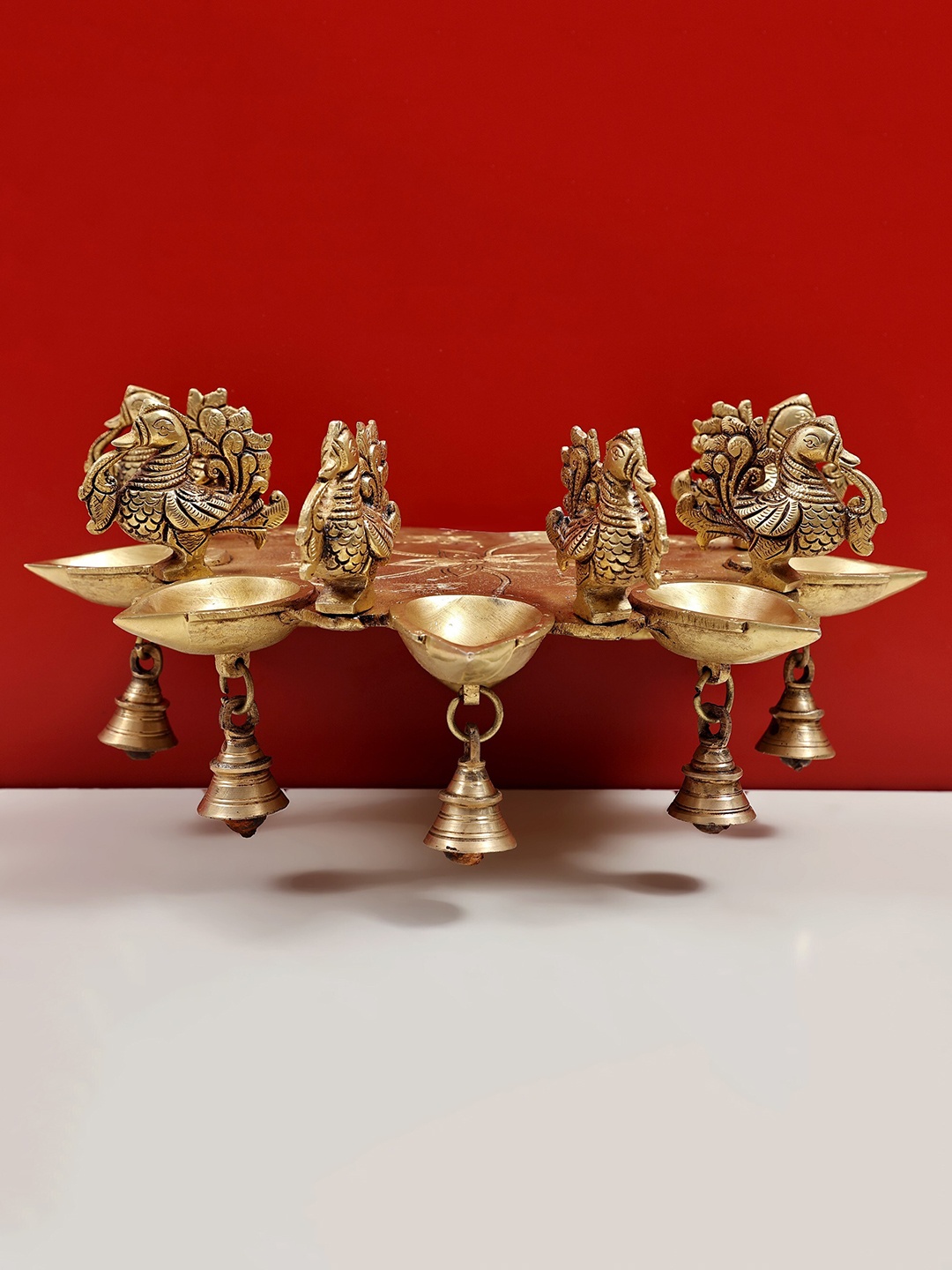 

Exotic India Brass Peacock Diya with Bells Wall Mount Bracket, Gold