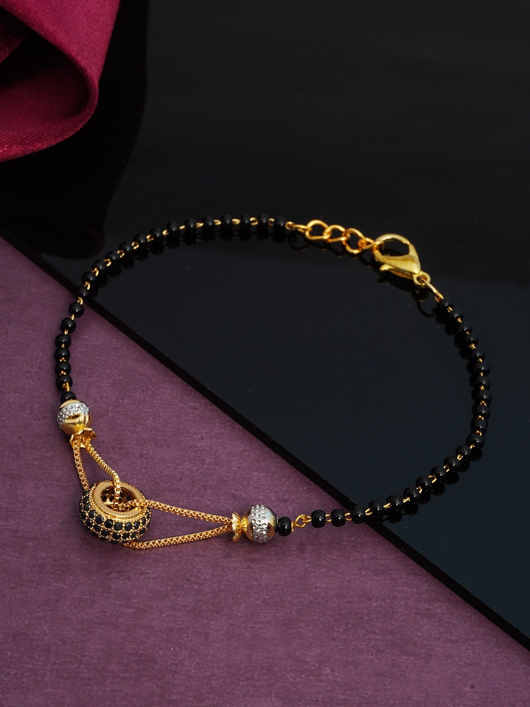

Urmika Women Gold-Toned & Black Charm Bracelet