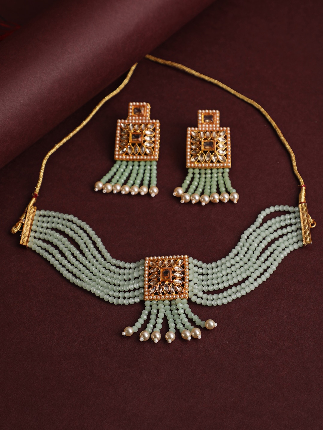 

Jazz and Sizzle Women Gold-Plated Green & White Kundan Studded & Beaded Jewellery Set