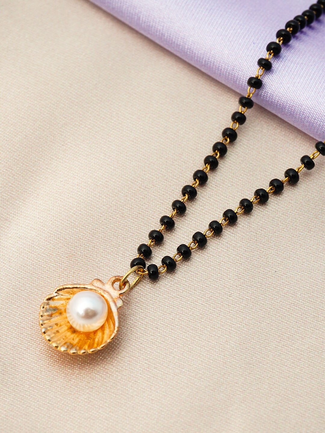 

Ferosh Black And Gold Toned Gold-Plated Pearl Seashell Pendant Beaded Mangalsutra