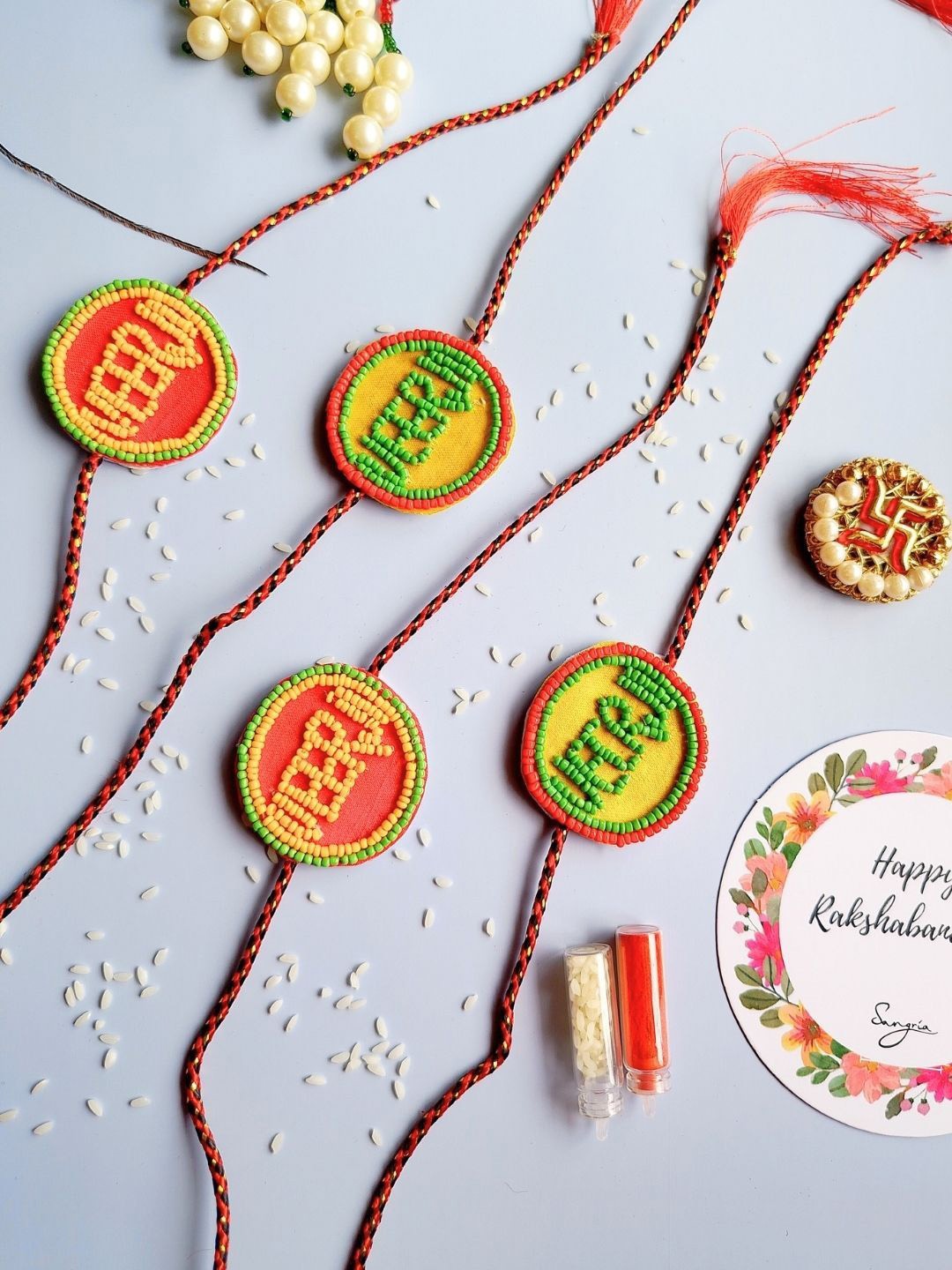 

Sangria Set of 4 Veerji Beaded Thread Rakhis With Roli Chawal & Greeting Card, Yellow