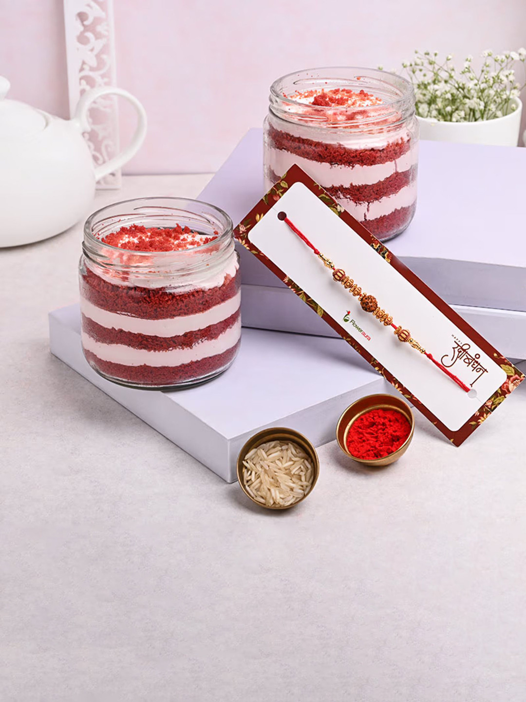 

Floweraura Rakhi With 2 Pcs Velvet Jar Cakes, Red