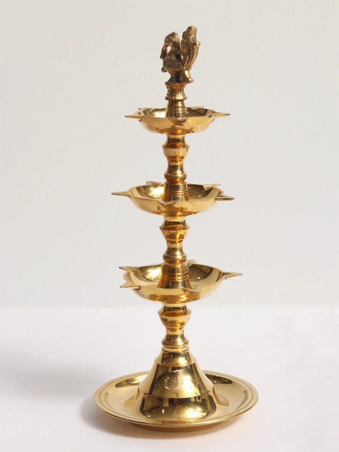 

Exotic India Gold Toned Peacock Three-Layer Oil Lamp