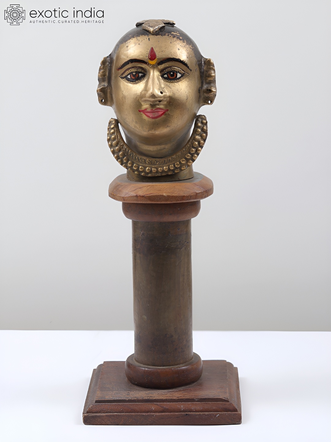 

Exotic India Gold-Toned Brass Gauri Head on Wooden Pedestal Idol Showpiece