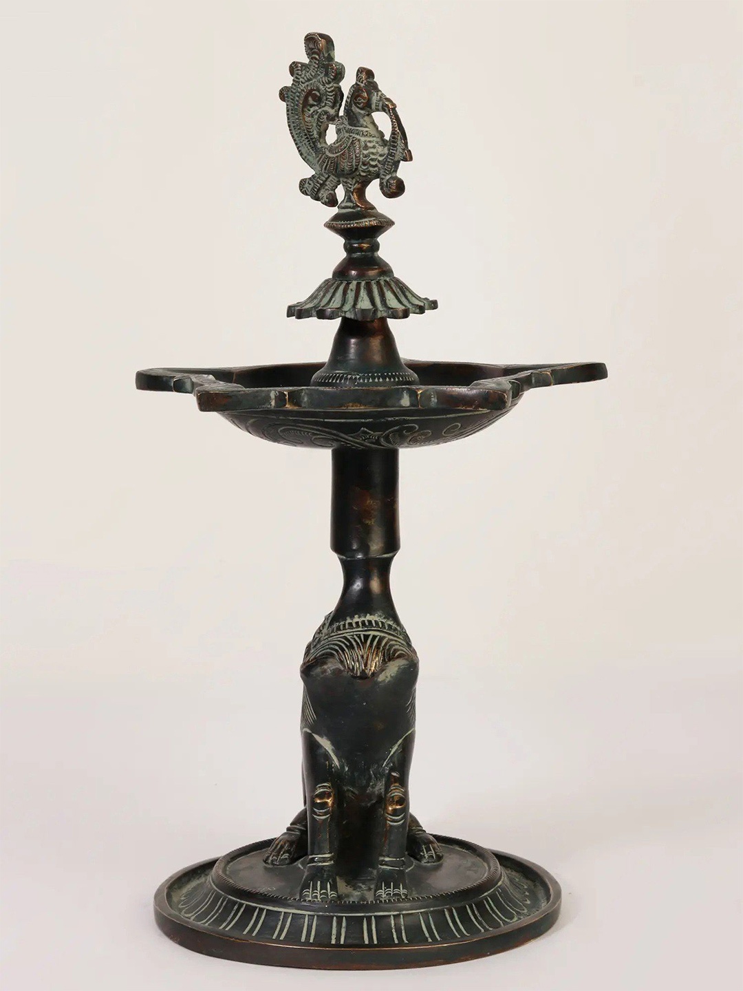 

Exotic India 12" Brass Five Wicks Designer Peacock Lamp on Lion Base, Black