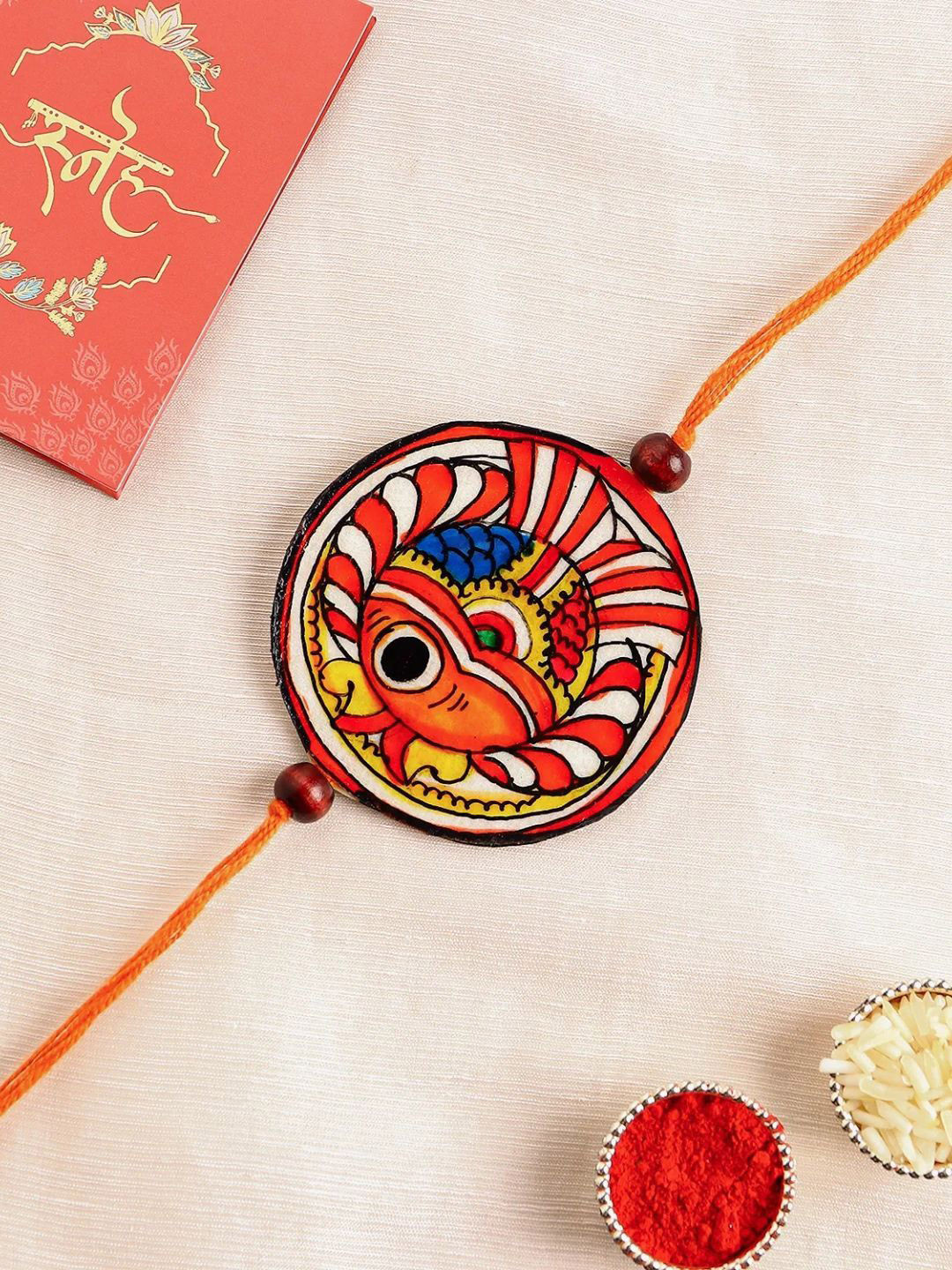 

fnp Tholpavakoothu Ritualistic Art Rakhi American Diamond, Red