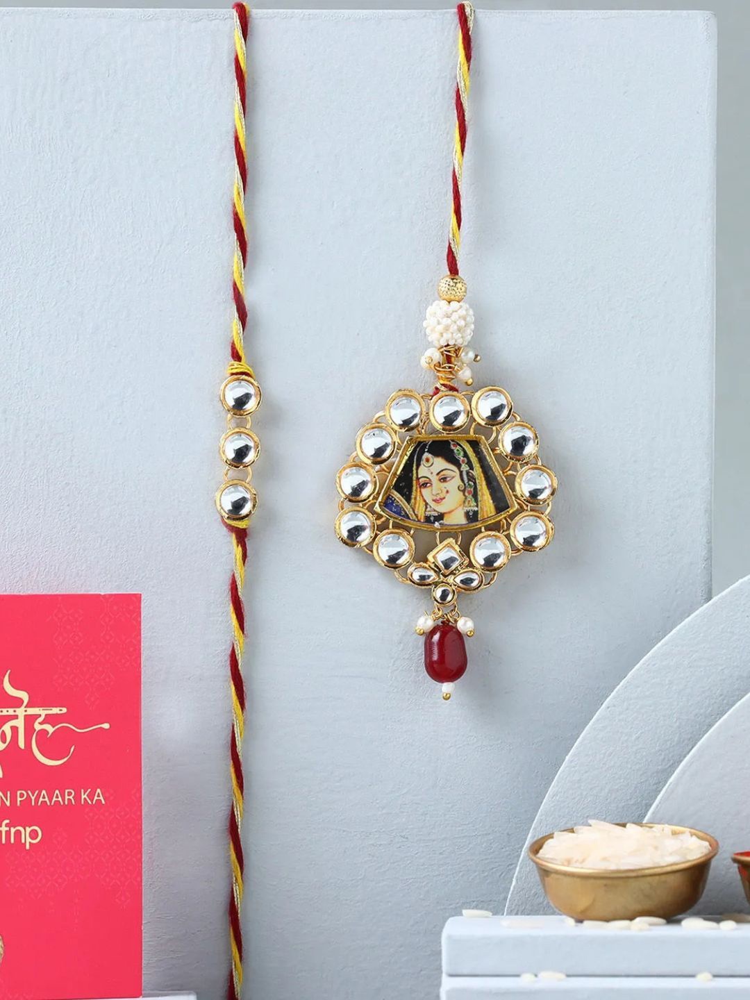 

fnp Ethnic Madhubani Lumba Rakhi Set Classic Pearls, Gold