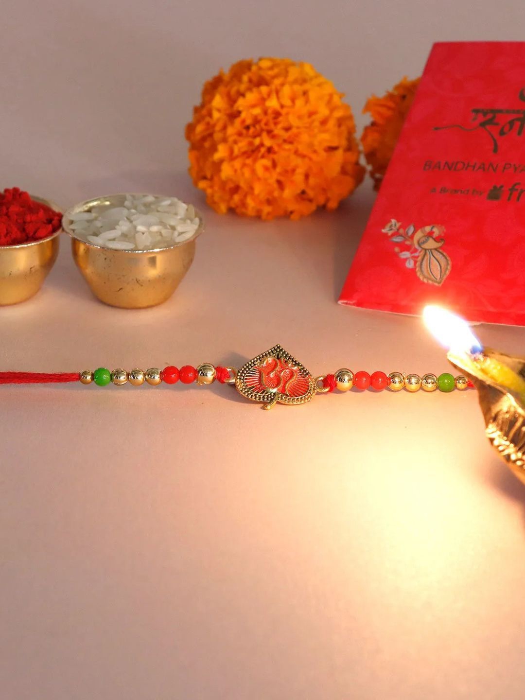 

fnp Rose Gold Reverie Om Rakhi Bhaiya-Bhabhi Rakhis