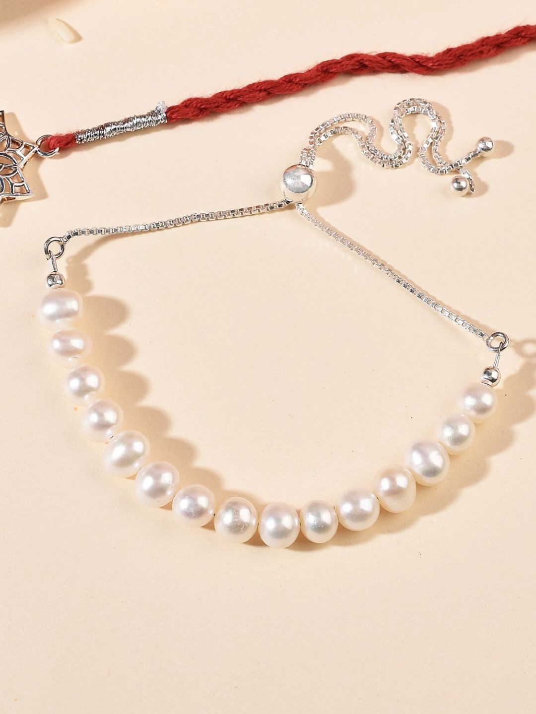 

fnp Ethereal Silver Rakhi & Pearl Bracelet Combo Magical Evil Eye
