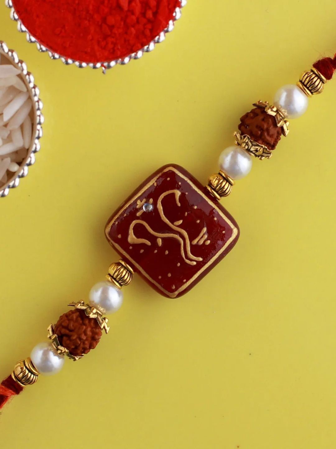 

fnp Ganeshas Blessing Rakhi Classic Pearls, Brown