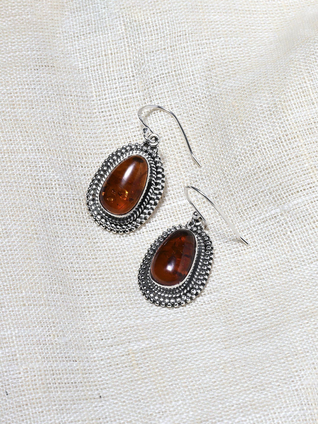 

Exotic India Oval Cut Amber Sterling Silver Earrings, Red