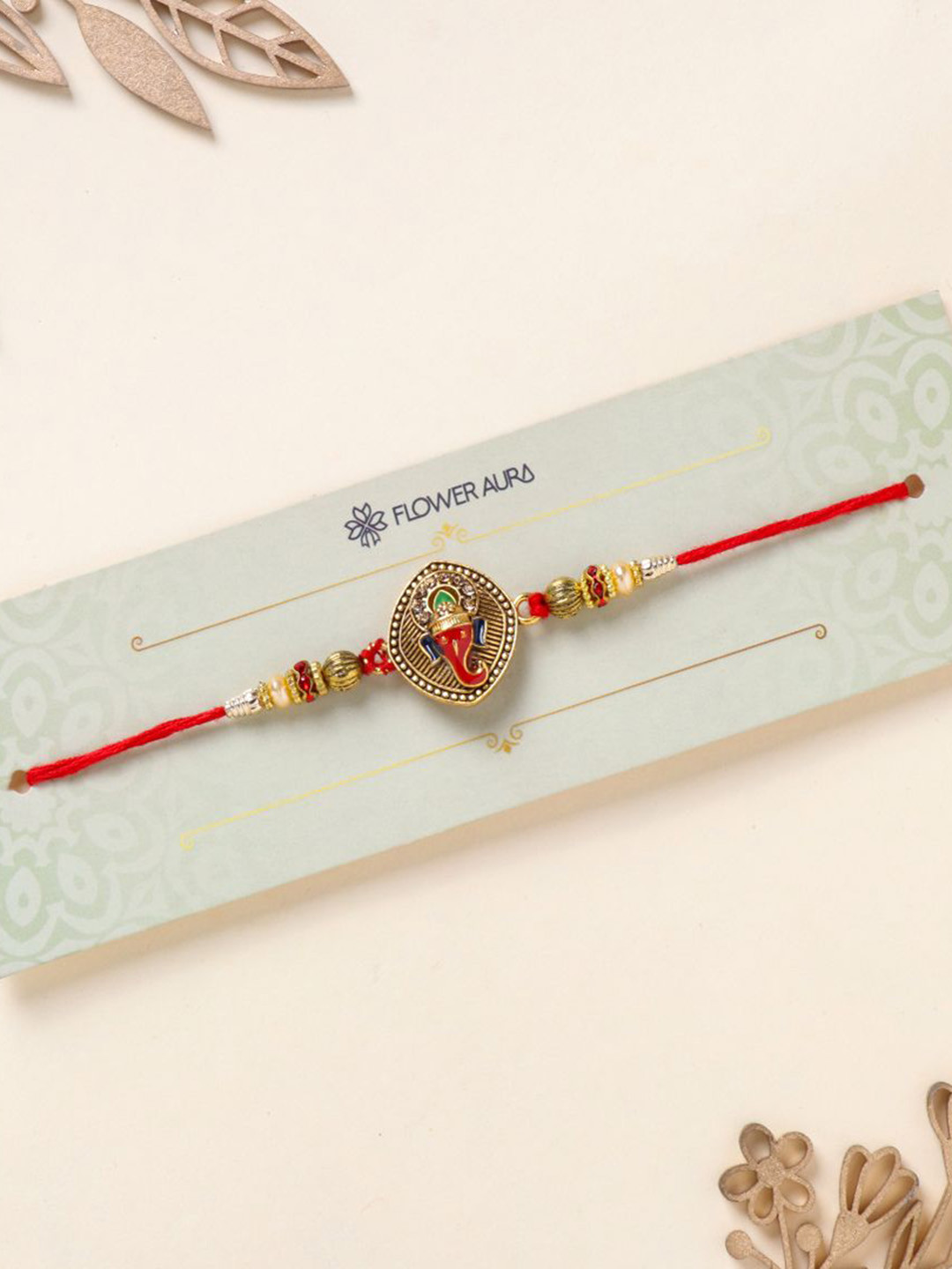 

Floweraura Antique Ganesh Charm Stone Studded & Beaded Thread Rakhi With Roli Chawal, Gold
