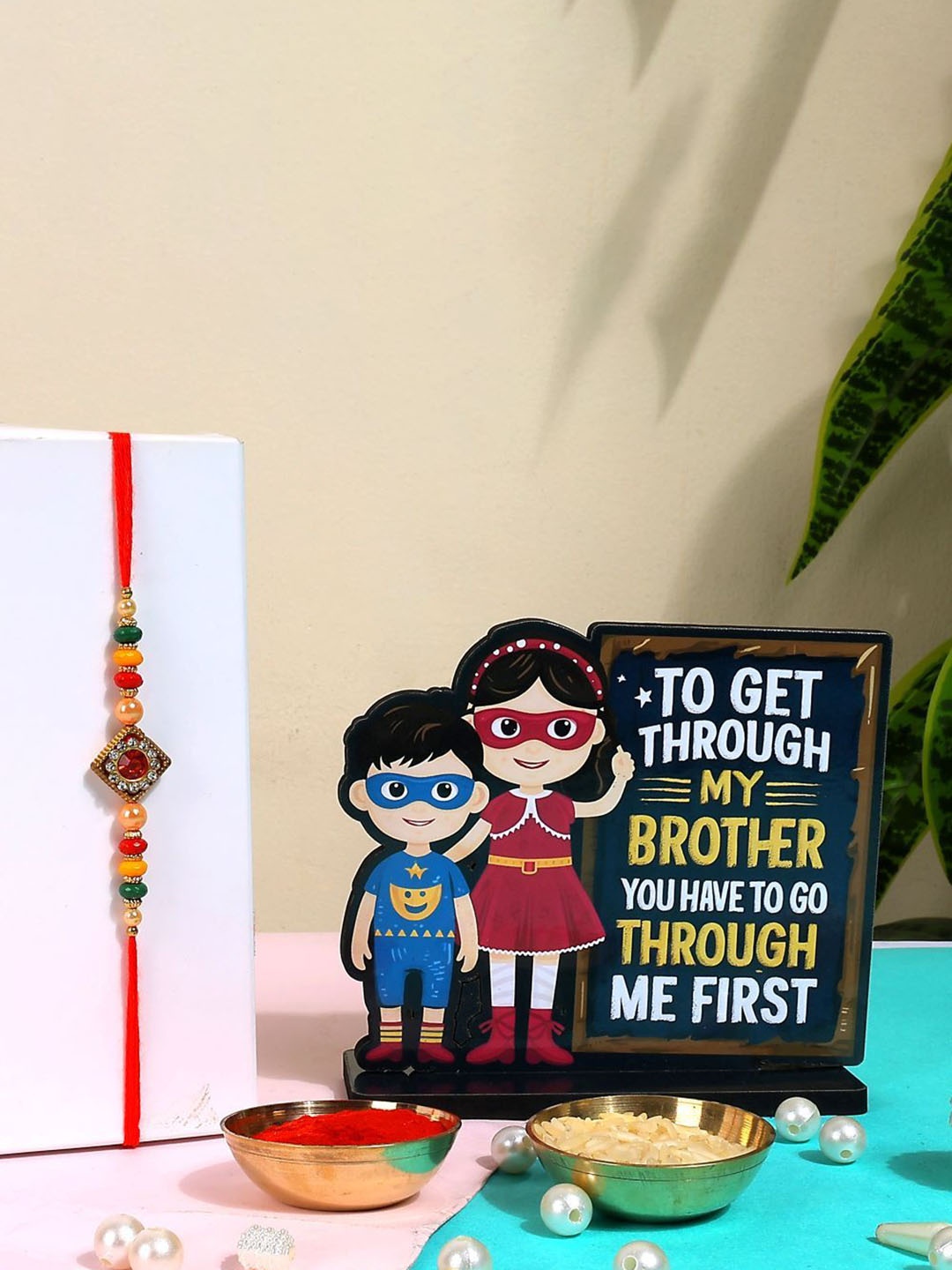 

Phirki Studio Set of 2 Beaded Thread Rakhi With Brosis Table Stand & Roli Chawal, Gold