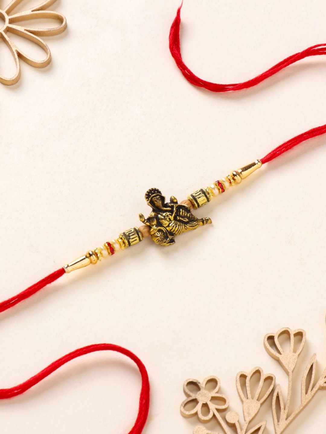 

Floweraura Ganesha Charm Stone Studded & Beaded Thread Rakhi With Roli Chawal, Red