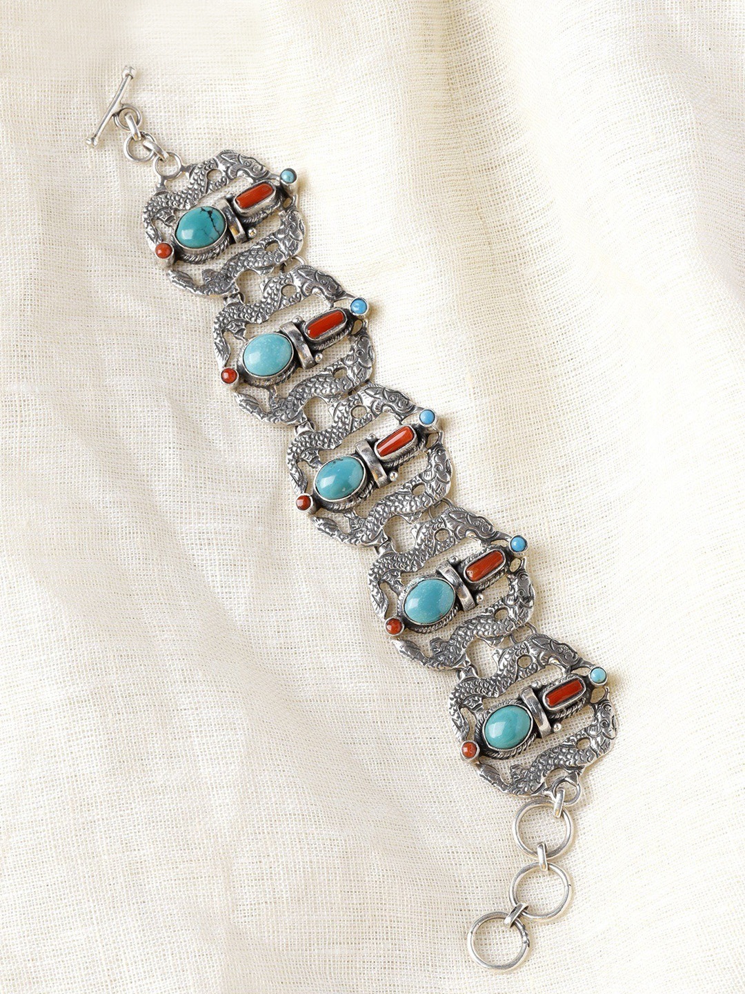 

Exotic India Coral and Arizona Turquoise Sterling Silver Tibetan Dragon Design Bracelet