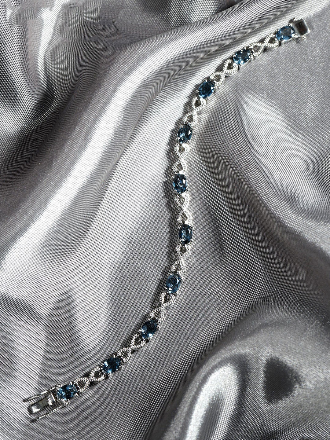 

Exotic India Faceted London Blue Topaz Sterling Silver Infinity Bracelet