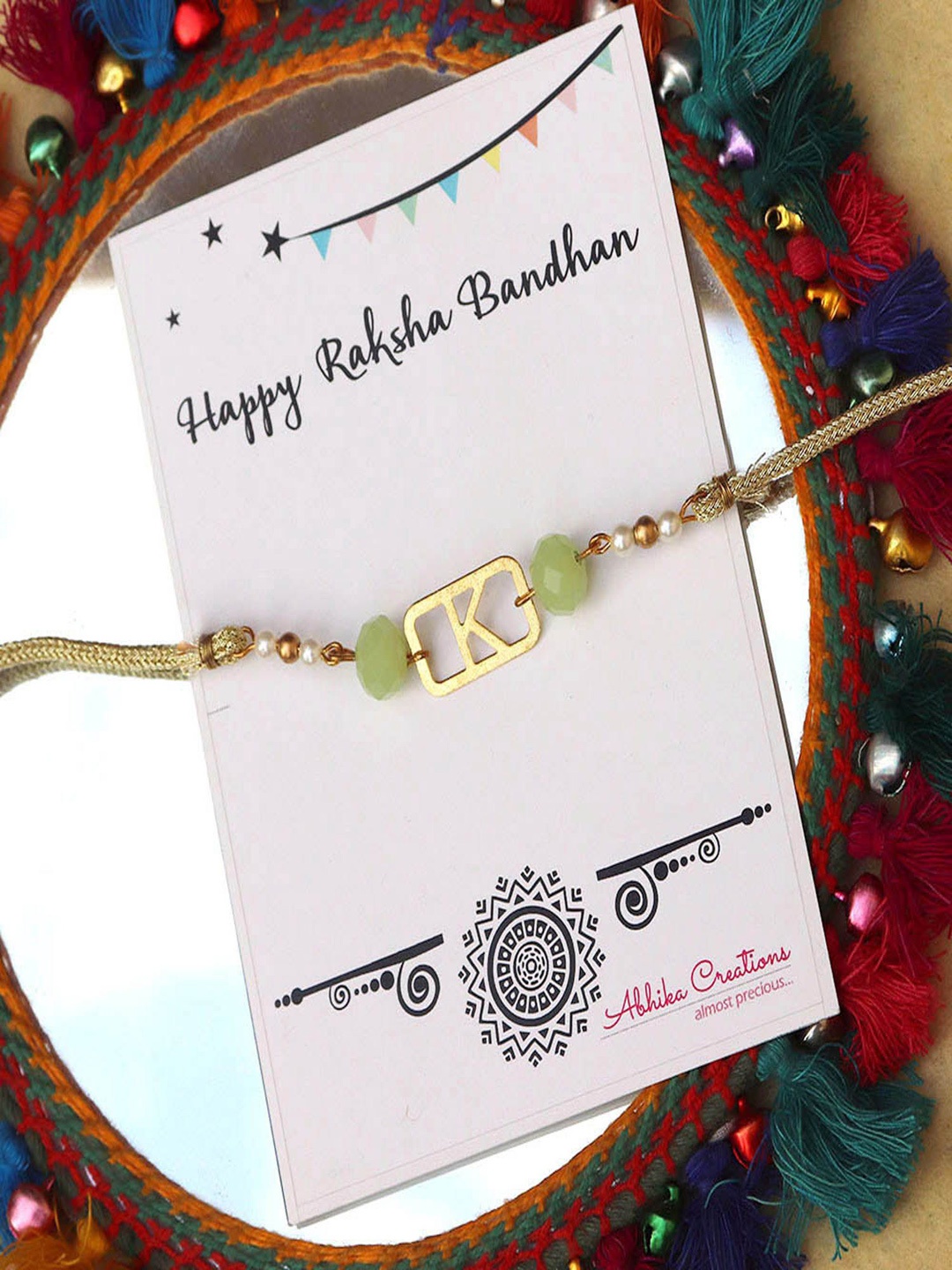 

BeAbhika V Initial Beaded Thread Rakhi with Roli Chawal Capsules, Green