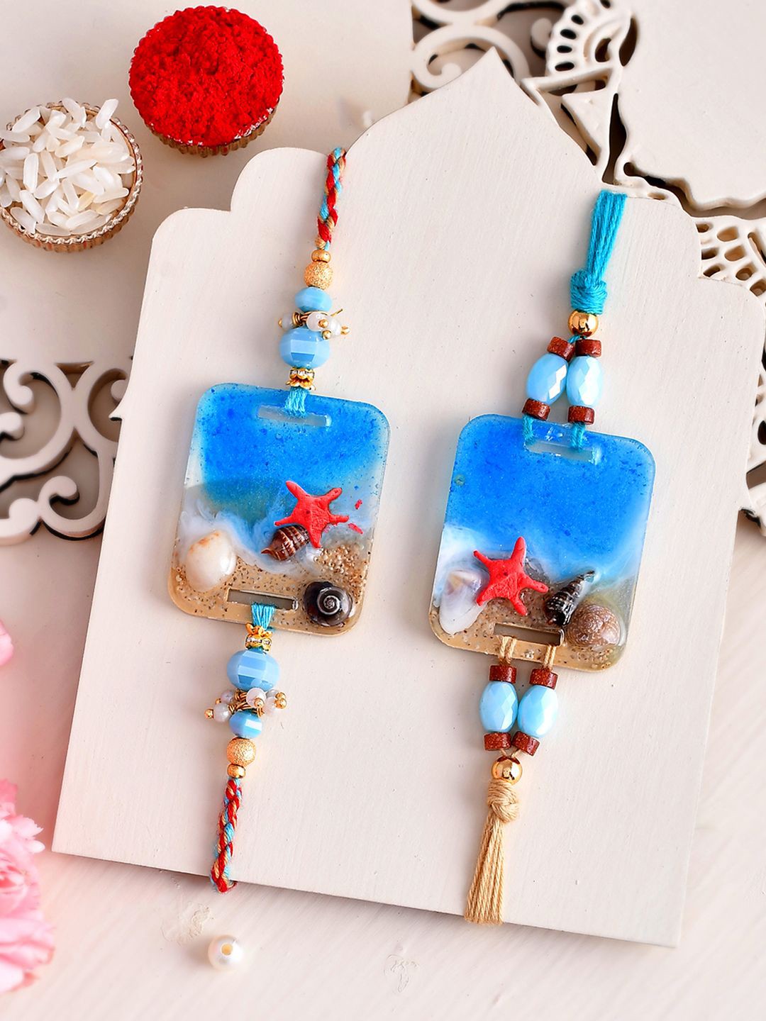 

Aapno Rajasthan Set Of 2 Thread Rakhi With Roli Chawal & Greeting Card, Blue