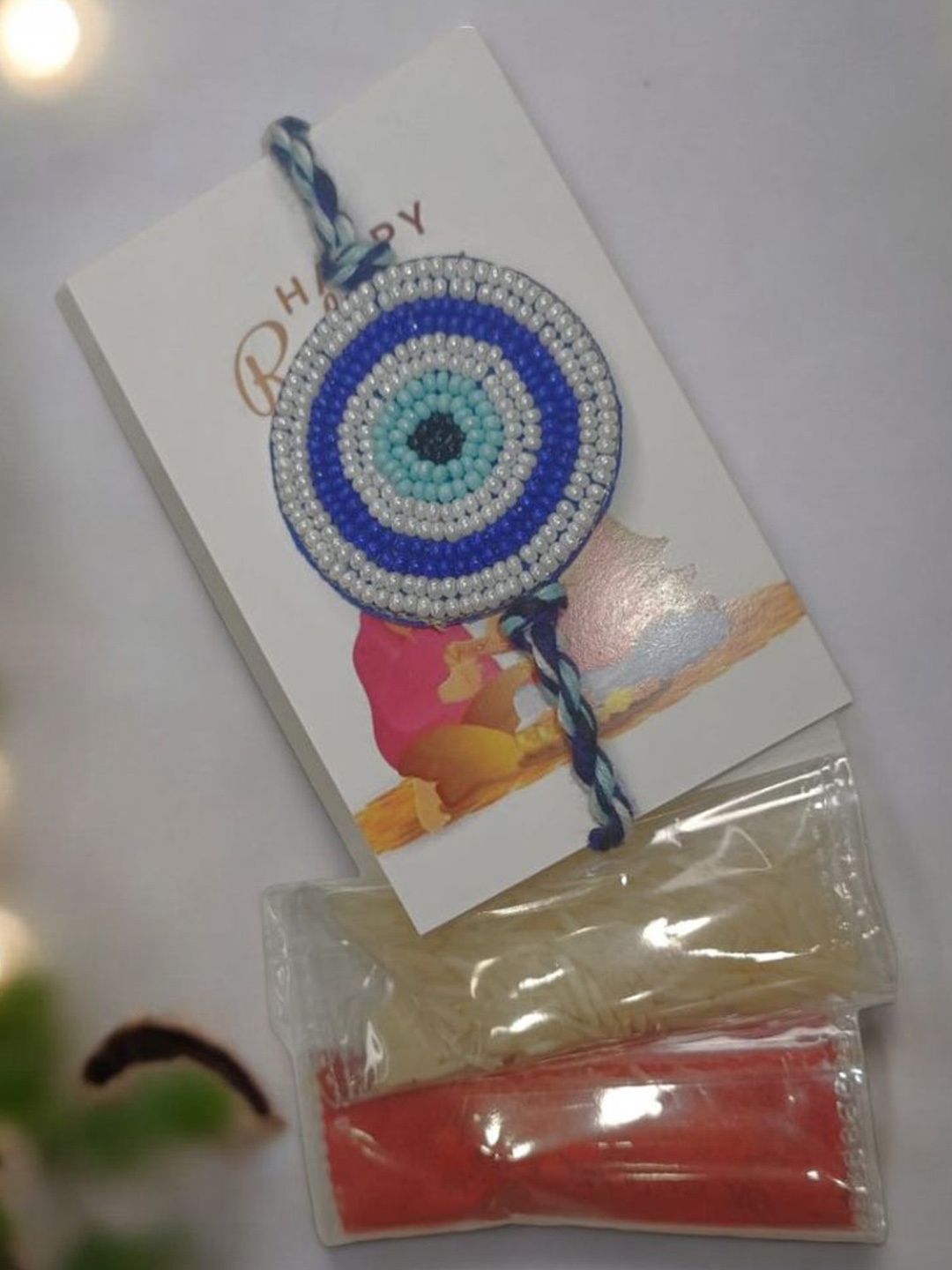 

PRIAANSHA CREATIONS Evil Eye Beaded Rakhi Thread Rakhi With Roli Chawal & Greeting Card, Blue