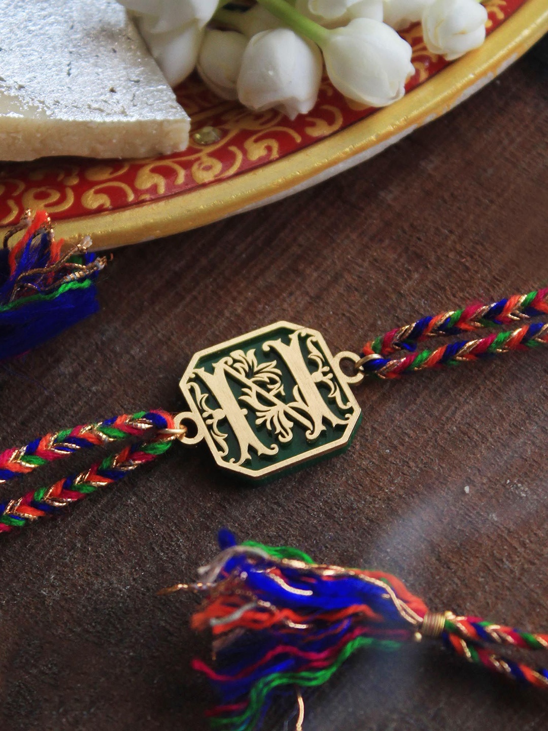 

BeAbhika G Floral Initial Acrylic Thread Rakhi with Roli Chawal Capsules, Red