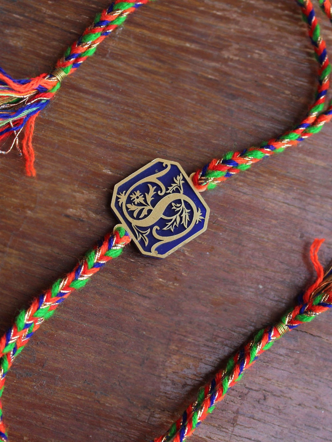 

BeAbhika M Initial Floral Thread Rakhi With Roli Chawal, Blue
