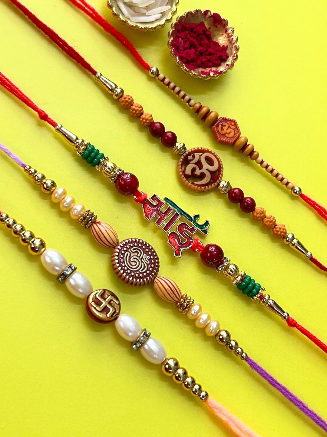 

LAIDA Set Of 5 Om Swastik & Bhai Gemstone Studded & Beaded Thread Rakhis With Roli Chawal, Red