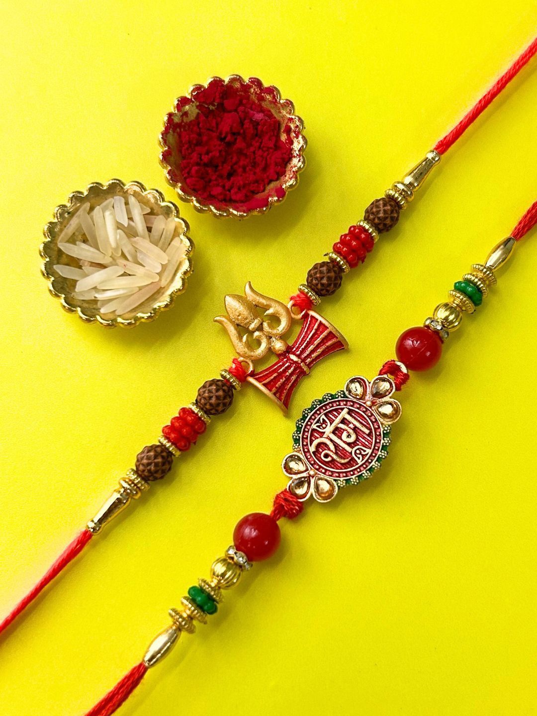 

LAIDA Set Of 2 Ram and Trishul Gemstone Studded & Beaded Thread Rakhis With Roli Chawal, Red