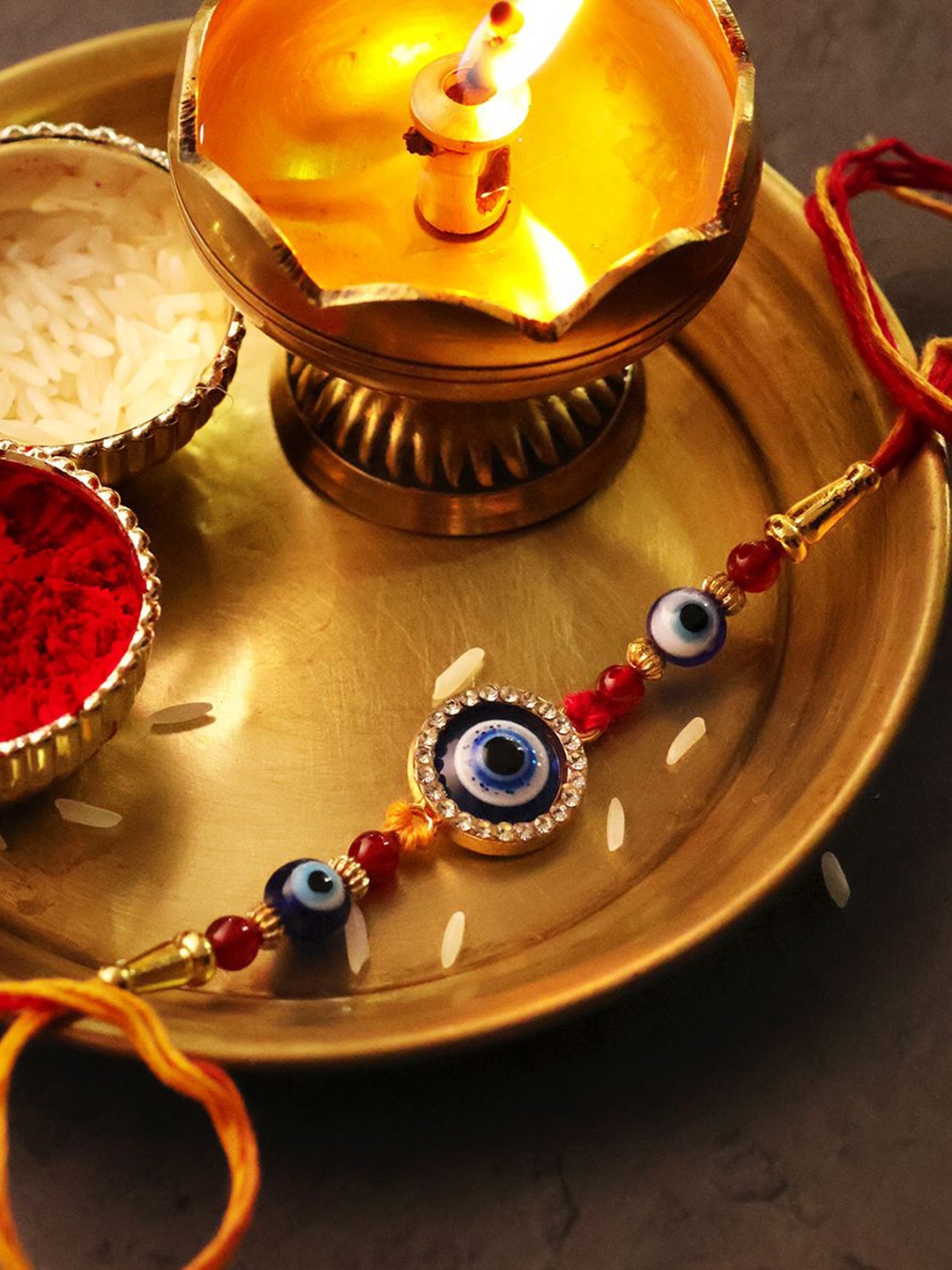 

Shubhanjali Set Of 2 Evil Eye Diamond Round Thread Rakhis With Roli Chawal & Greeting Card, Blue