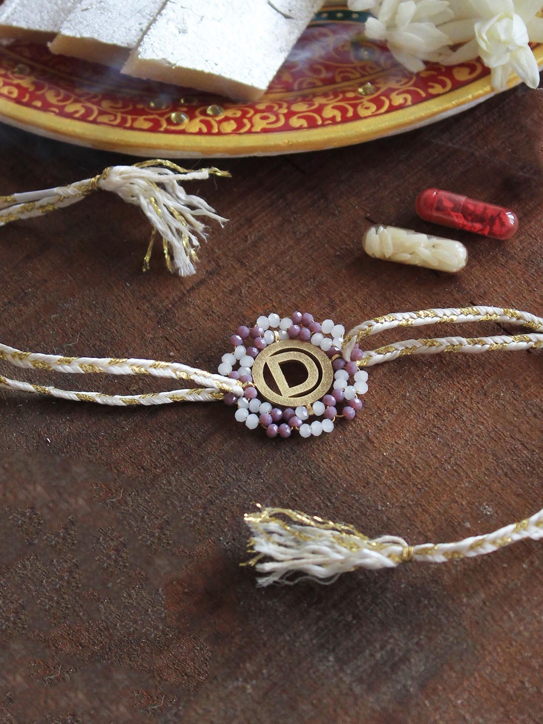 

BeAbhika R Initial Floral Beaded Thread Rakhi With Roli Chawal, White